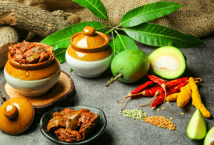 Jars of homemade mango pickle with chillies and turmeric